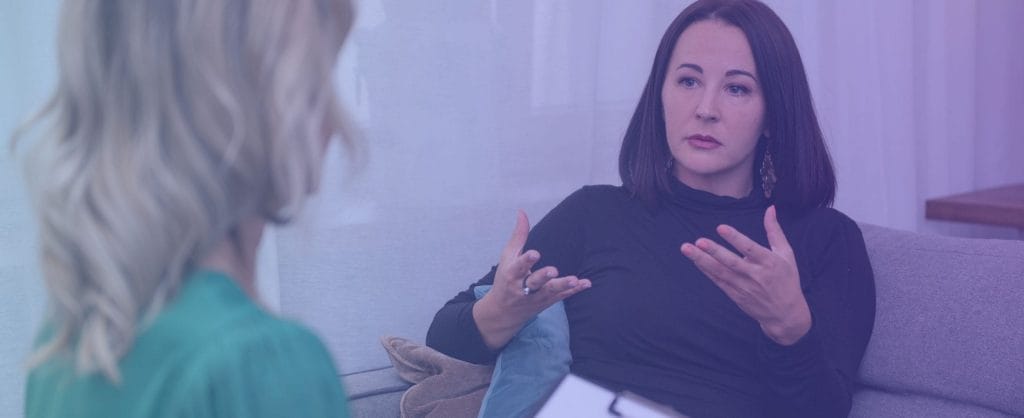 Woman talking to another woman holding a clipboard
