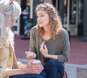 Two women sitting together and having a conversation