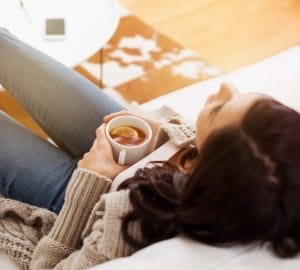 woman relaxing on couch with a cup of tea