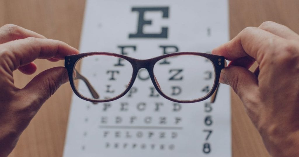 eye glasses being held over an eye chart