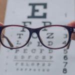 eye glasses being held over an eye chart